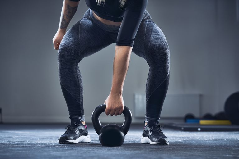close-up-of-athletic-woman-exercising-with-kettlebell-at-gym.jpg